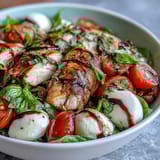 A vibrant Caprese Chicken Bowl features juicy grilled chicken, creamy mozzarella, and ripe tomatoes.