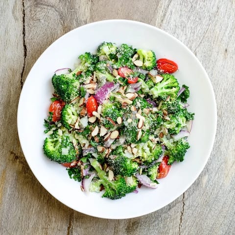 Fresh Garlic Parmesan Broccoli Salad served chilled as a side, featuring crisp vegetables, tangy dressing, and a sprinkle of Parmesan cheese.