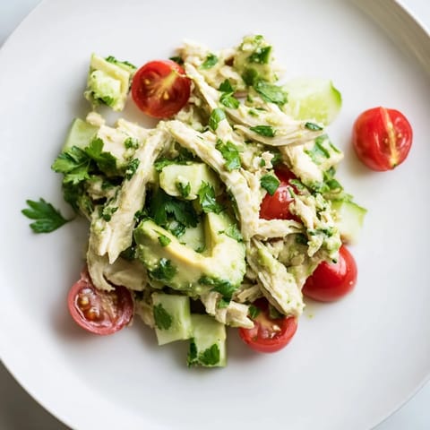 Freshly prepared Avocado Chicken Salad featuring crisp cucumber, red onion, and fragrant cilantro, served as a healthy and gluten-free light lunch option.