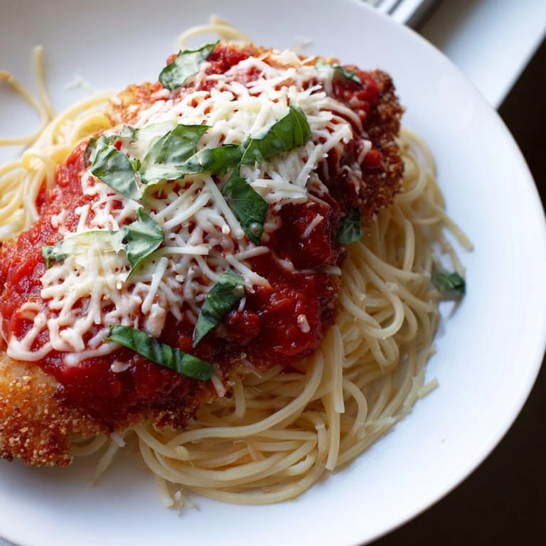 A close-up of delicious Chicken Parmesan, featuring melted cheese and a flavorful marinara sauce.