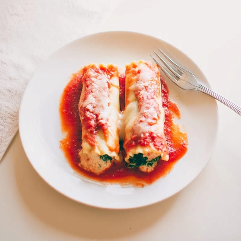 Close-up of Chicken and Spinach Lasagna Rolls, showcasing creamy ricotta, tender chicken, and vibrant spinach filling.