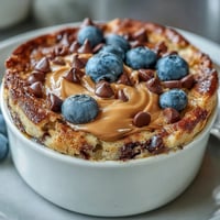Golden Baked Protein Pancake Bowl fresh from the oven, topped with maple syrup and peanut butter.