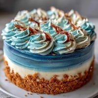 Graduation cake with dark blue and gold ombre layers, decorated with elegant gold accents for a festive celebration.